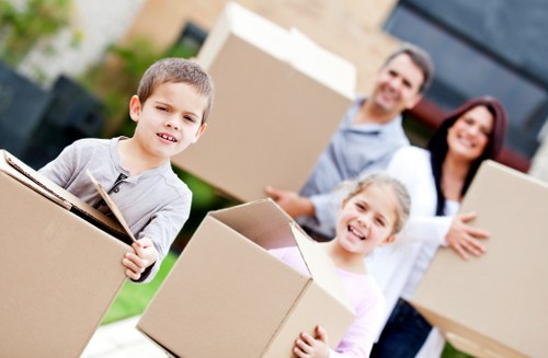 Movers carrying furniture through a residential street in Bromley